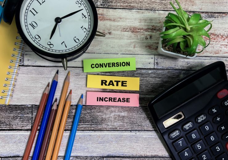 Concept of Conversion Rate Increase write on sticky notes isolated on Wooden Table.